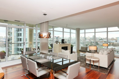 Immagine di una sala da pranzo aperta verso il soggiorno contemporanea di medie dimensioni con parquet scuro, pavimento marrone e camino classico