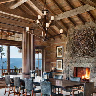 Idee per un'ampia sala da pranzo stile rurale con pareti marroni, pavimento in legno massello medio, camino classico, cornice del camino in pietra e pavimento marrone