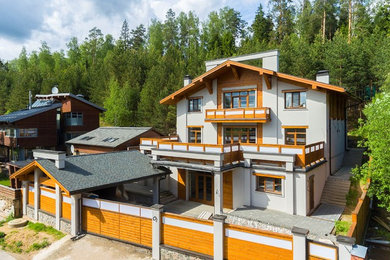 Imagen de fachada de casa beige actual grande de tres plantas con revestimientos combinados, tejado a dos aguas y tejado de teja de madera