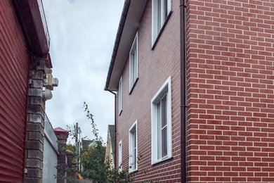 Стильный дизайн: двухэтажный, кирпичный, красный частный загородный дом среднего размера - последний тренд