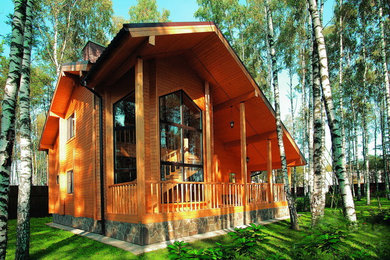 Пример оригинального дизайна: большой, двухэтажный, деревянный, коричневый частный загородный дом в стиле кантри с двускатной крышей и черепичной крышей