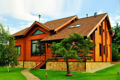 Стильный дизайн: двухэтажный, деревянный, коричневый частный загородный дом среднего размера в стиле кантри с двускатной крышей и крышей из гибкой черепицы - последний тренд