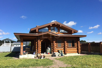 На фото: двухэтажный, деревянный, коричневый частный загородный дом среднего размера в классическом стиле с двускатной крышей и крышей из гибкой черепицы