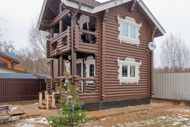 Пример оригинального дизайна: маленький, двухэтажный, деревянный, коричневый частный загородный дом с мансардной крышей и крышей из гибкой черепицы для на участке и в саду