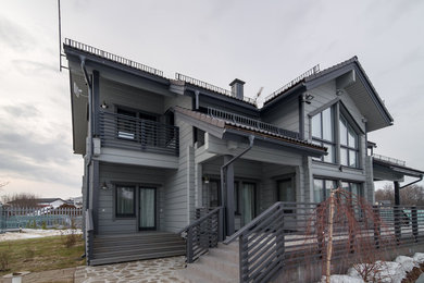 Zweistöckige Klassische Holzfassade Haus mit grauer Fassadenfarbe und Satteldach in Moskau