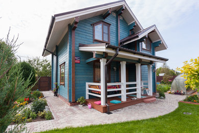 Пример оригинального дизайна: двухэтажный, деревянный, синий частный загородный дом в стиле кантри с двускатной крышей