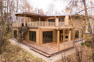 На фото: двухэтажный, деревянный, коричневый частный загородный дом среднего размера в современном стиле с односкатной крышей и металлической крышей с