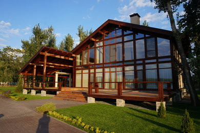 Пример оригинального дизайна: двухэтажный, коричневый частный загородный дом среднего размера в современном стиле с комбинированной облицовкой, двускатной крышей и крышей из гибкой черепицы