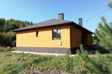 Пример оригинального дизайна: одноэтажный, оранжевый частный загородный дом среднего размера в стиле неоклассика (современная классика) с комбинированной облицовкой, вальмовой крышей и металлической крышей