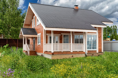 На фото: большой, двухэтажный частный загородный дом в скандинавском стиле с двускатной крышей с