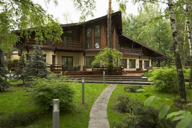 Пример оригинального дизайна: большой, двухэтажный, коричневый дом в стиле кантри