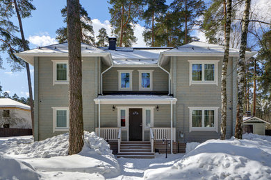 На фото: двухэтажный, деревянный, серый частный загородный дом в скандинавском стиле с