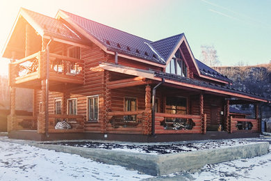 На фото: двухэтажный, деревянный, коричневый частный загородный дом среднего размера в стиле кантри с полувальмовой крышей и металлической крышей с