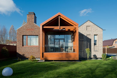 Стильный дизайн: одноэтажный, кирпичный, разноцветный дом среднего размера в современном стиле с двускатной крышей - последний тренд