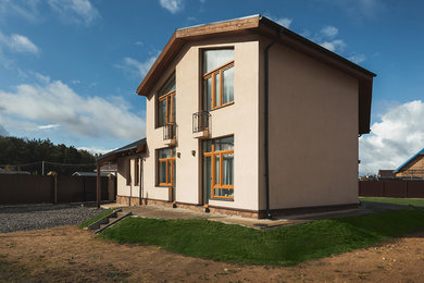 На фото: двухэтажный, белый частный загородный дом среднего размера в современном стиле с облицовкой из цементной штукатурки, вальмовой крышей и крышей из гибкой черепицы