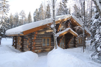 На фото: большой, одноэтажный, деревянный, серый частный загородный дом в стиле рустика с двускатной крышей