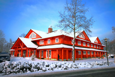 На фото: огромный, деревянный многоквартирный дом в стиле неоклассика (современная классика) с мансардной крышей и черепичной крышей с