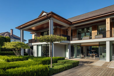 Стильный дизайн: двухэтажный, деревянный, коричневый частный загородный дом в современном стиле с двускатной крышей - последний тренд