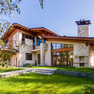 Immagine della facciata di una casa unifamiliare beige contemporanea a due piani di medie dimensioni con tetto a capanna, copertura a scandole e rivestimento in pietra