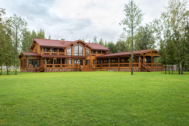 Diseño de fachada de casa marrón rural grande de dos plantas con tejado a dos aguas, tejado de metal y revestimiento de madera
