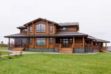 Идея дизайна: двухэтажный, деревянный, коричневый частный загородный дом в стиле кантри с двускатной крышей
