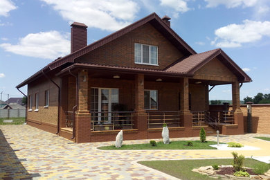 Diseño de fachada marrón contemporánea de tamaño medio de dos plantas con revestimiento de ladrillo y tejado a dos aguas