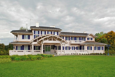 Imagen de fachada de casa blanca clásica renovada extra grande de tres plantas con revestimiento de madera