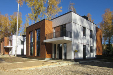 Modelo de fachada de casa multicolor escandinava de tamaño medio de dos plantas con revestimiento de madera, tejado plano y tejado de varios materiales