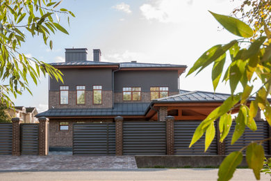 Diseño de fachada de casa marrón clásica renovada grande de tres plantas con revestimientos combinados, tejado a cuatro aguas y tejado de metal