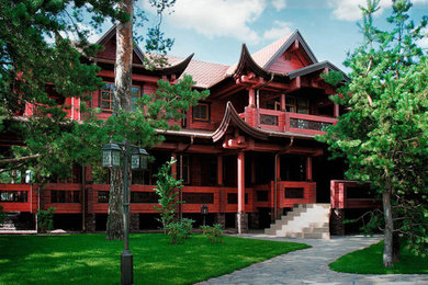 Foto della villa rossa etnica a due piani con rivestimento in legno
