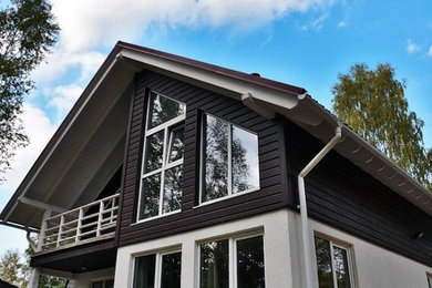 Modelo de fachada de casa blanca marinera de tamaño medio de dos plantas con revestimientos combinados, tejado a dos aguas y tejado de teja de barro
