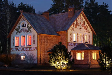 На фото: двухэтажный, деревянный, коричневый частный загородный дом в стиле кантри с двускатной крышей с