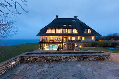 Foto de fachada de casa blanca ecléctica grande con revestimientos combinados y tejado a cuatro aguas