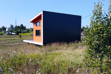 Пример оригинального дизайна: маленький частный загородный дом в скандинавском стиле с разными уровнями, комбинированной облицовкой, односкатной крышей и металлической крышей для на участке и в саду