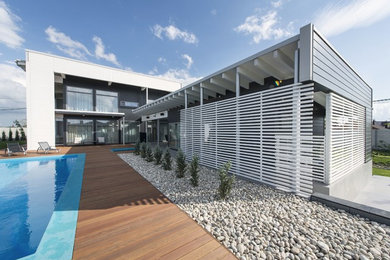 Diseño de fachada contemporánea de tamaño medio de dos plantas con revestimiento de madera y tejado plano