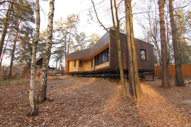 Diseño de fachada de casa marrón contemporánea de tamaño medio de una planta con revestimiento de madera, tejado de un solo tendido y tejado de metal