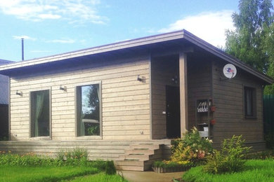 Идея дизайна: маленький, одноэтажный, деревянный, серый частный загородный дом в скандинавском стиле с односкатной крышей и крышей из гибкой черепицы для на участке и в саду