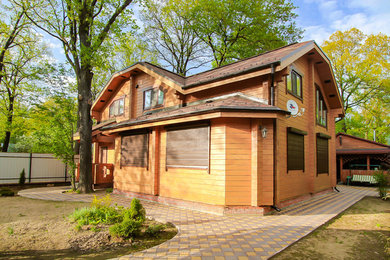 На фото: двухэтажный, деревянный, бежевый частный загородный дом среднего размера в стиле кантри с мансардной крышей и крышей из гибкой черепицы с