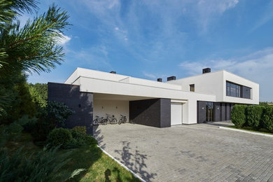 Imagen de fachada de casa blanca actual grande a niveles con revestimientos combinados y tejado plano