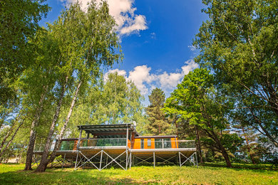 Exemple d'une façade de maison marron méditerranéenne en bois de taille moyenne et de plain-pied avec un toit à deux pans et un toit en shingle.