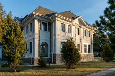 Foto de fachada de casa beige clásica renovada grande de dos plantas con revestimiento de piedra y tejado de teja de madera