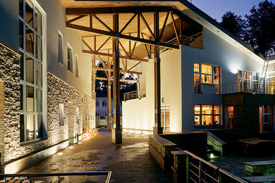 Источник вдохновения для домашнего уюта: большой, белый дом в современном стиле с разными уровнями, облицовкой из камня и двускатной крышей