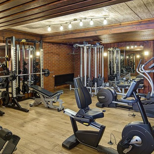 Immagine di una sala pesi country con pareti marroni, pavimento in legno massello medio e pavimento marrone