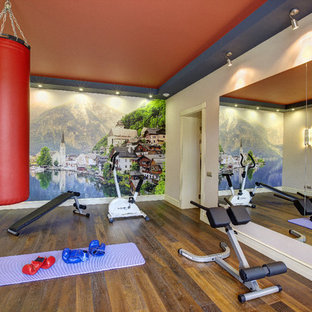 Immagine di una palestra multiuso minimal con pareti multicolore, pavimento in legno massello medio e pavimento marrone