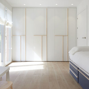 Idée de décoration pour une grand chambre d'enfant de 1 à 3 ans minimaliste avec un mur blanc, un sol en carrelage de porcelaine et un sol beige.