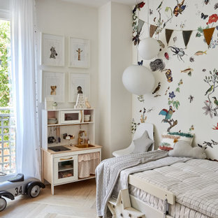 Modelo de dormitorio infantil contemporáneo con paredes multicolor, suelo de madera clara y suelo beige