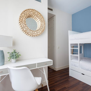 Imagen de dormitorio infantil costero con paredes azules, suelo de madera oscura y suelo marrón
