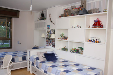 This is an example of a large classic gender neutral children’s room in Other with white walls and medium hardwood flooring.