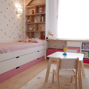 Esempio di una piccola cameretta per bambini da 4 a 10 anni stile shabby con pareti bianche, parquet chiaro, pavimento marrone e carta da parati