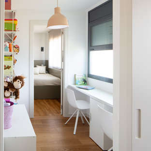 Diseño de habitación infantil unisex contemporánea con escritorio, paredes blancas, suelo de madera en tonos medios y suelo marrón